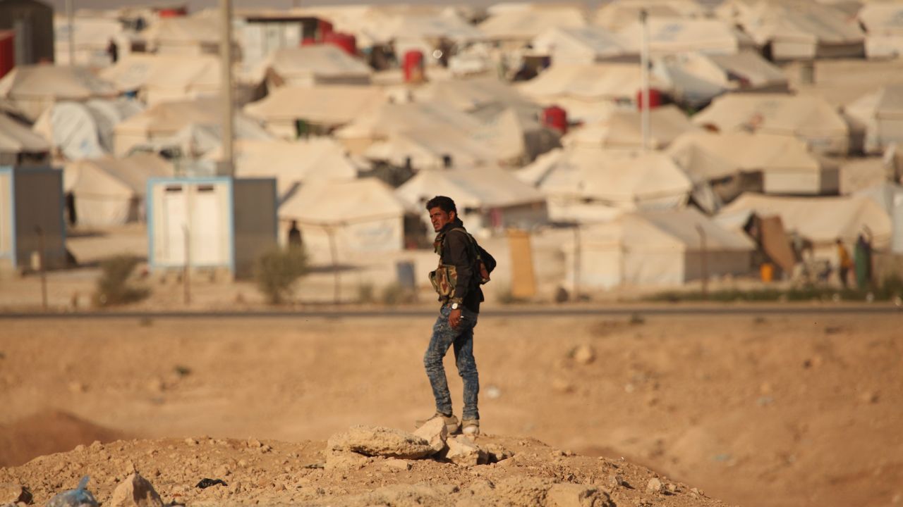 An armed guard watches over a camp housing suspected ISIS families from Raqqa.