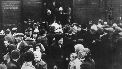 Jews deported from Hungary exit a German boxcar onto a crowded railway platform at Auschwitz concentration camp, Poland, in 1944. 