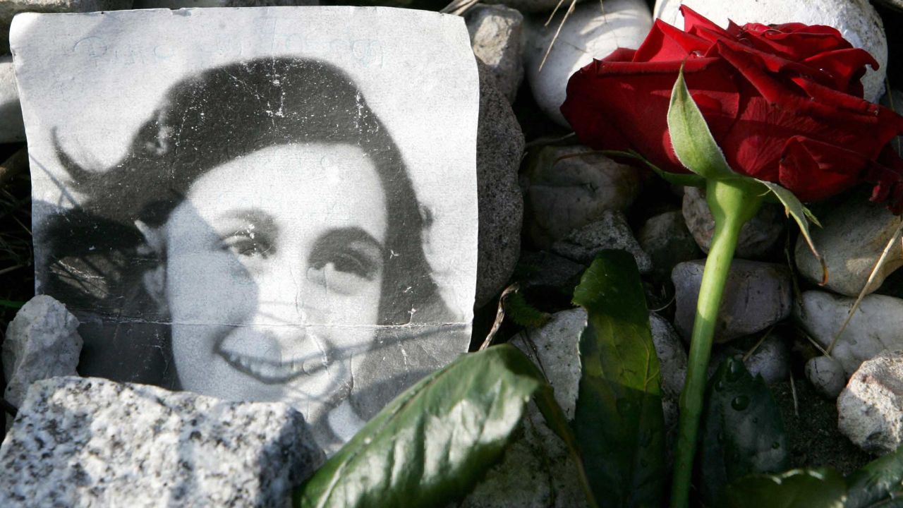 A picture of Anne Frank in front of her memorial stone at the former Bergen-Belsen concentration camp.