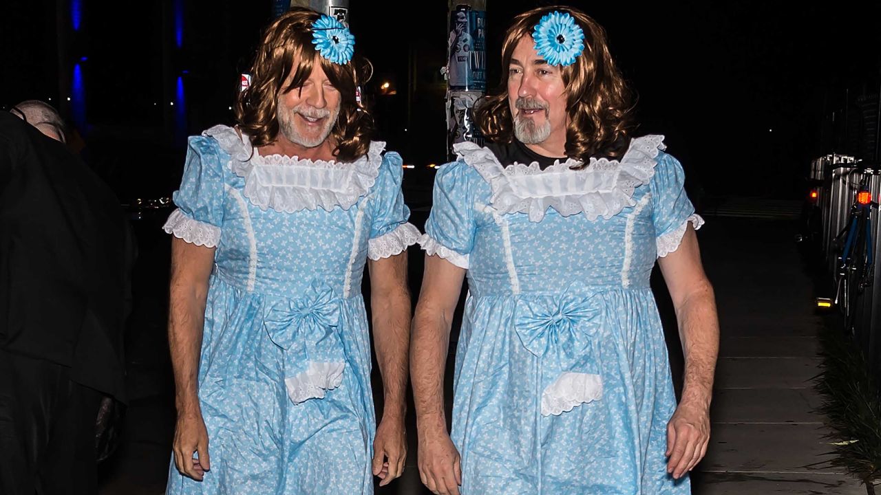 Bruce Willis, left, shows up as one of the Grady twins at director M. Night Shyamalan's Halloween party. 
