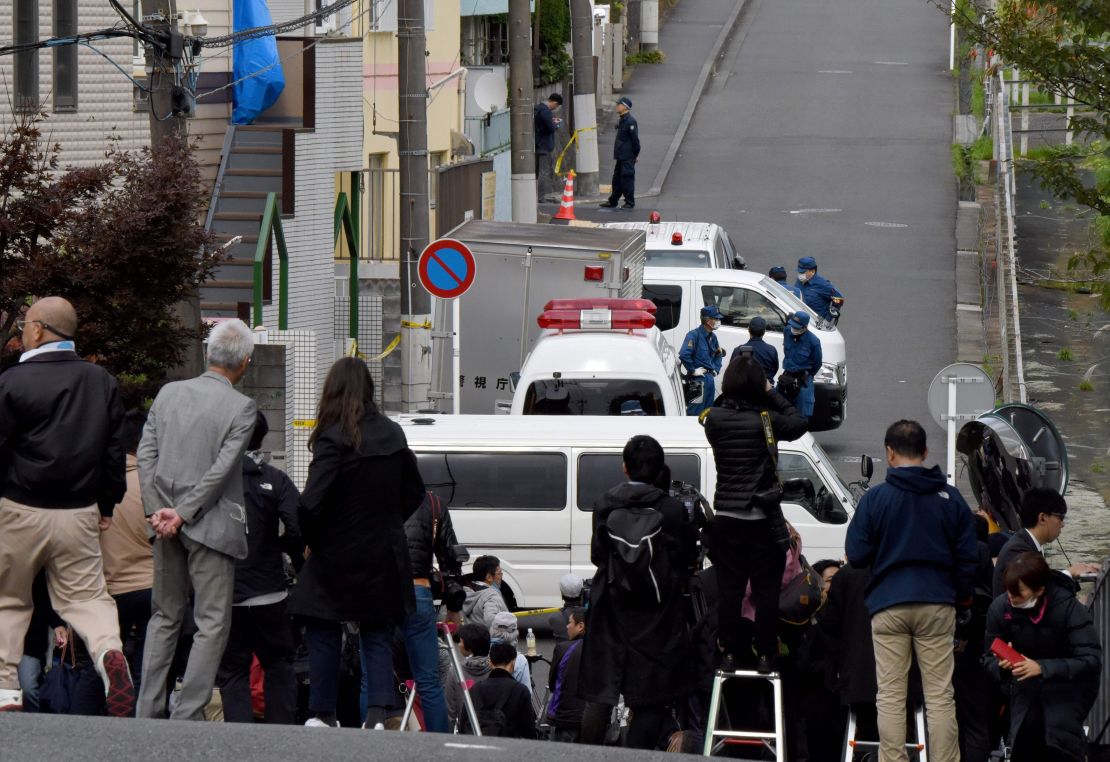 Media gather in front of an apartment (partialy covered with a blue sheet) where Japanese police found body parts in a suburb of Tokyo. 