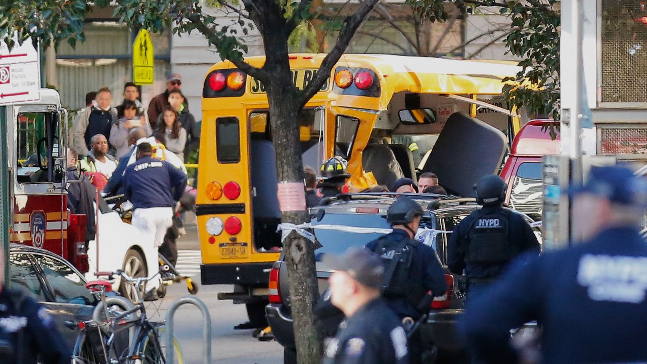 Four people on the school bus had minor injuries after the truck crashed into it, a police official said. After hitting the bus, the driver exited the truck and was shot by police while displaying imitation firearms, according to the NYPD. 
