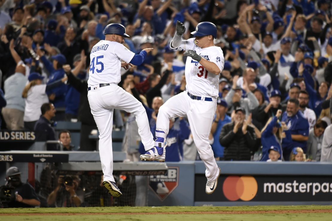 Joc Pederson celebrates with third base coach Chris Woodward after hitting a solo home run in the seventh inning.