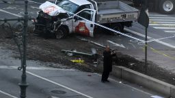 An investigator takes pictures with his phone near a pickup truck following an incident in New York on October 31, 2017. 
A pickup driver killed eight people in New York on Tuesday, mowing down cyclists and pedestrians, before striking a school bus in what officials branded a "cowardly act of terror." Eleven others were seriously injured in the broad daylight assault and first deadly terror-related attack in America's financial and entertainment capital since the September 11, 2001 Al-Qaeda hijackings brought down the Twin Towers.
 / AFP PHOTO / Don EMMERT        (Photo credit should read DON EMMERT/AFP/Getty Images)