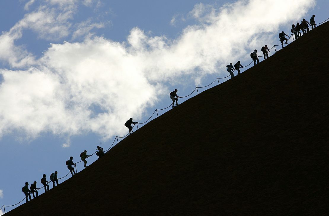 Tourists climb the monolith of Uluru to reach the 340m summit.