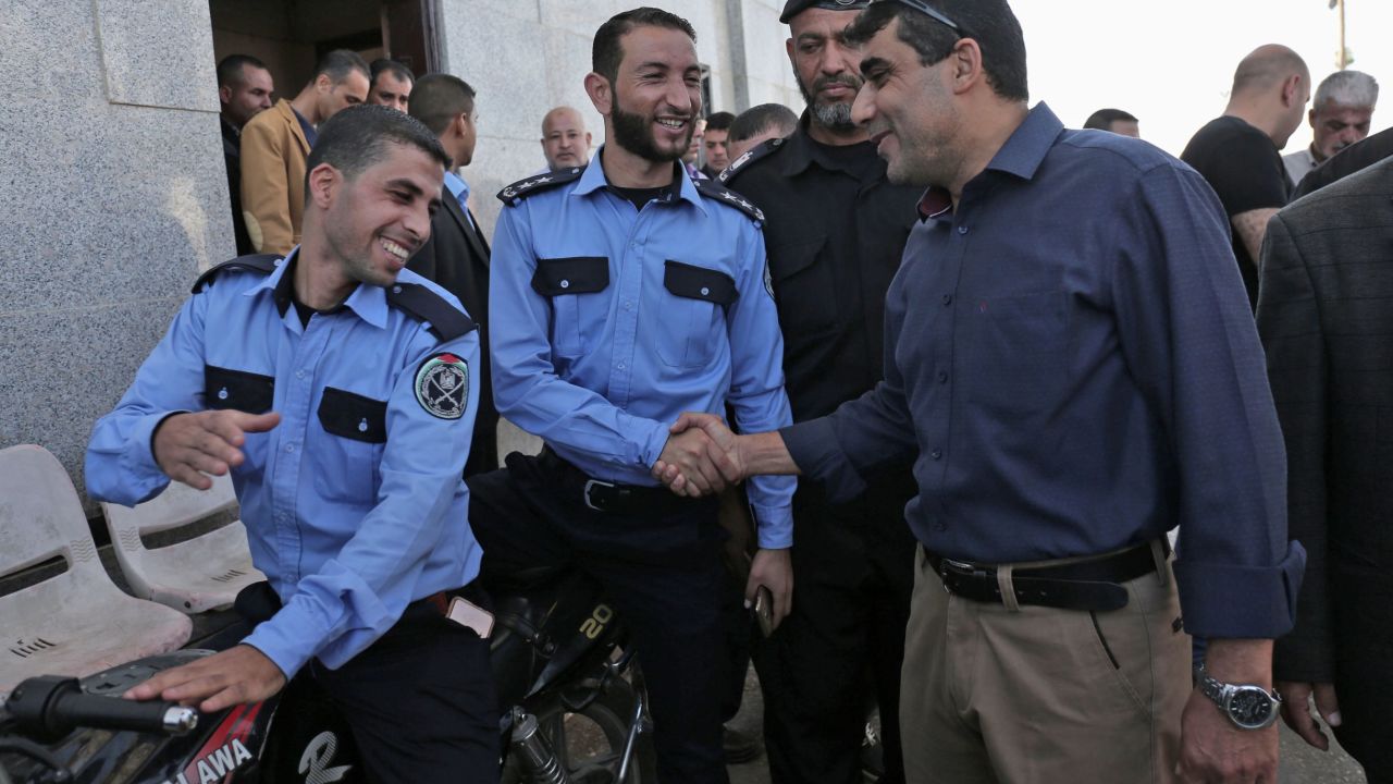 A member of the Palestinian Authority (R) shakes hands with security officers at the Rafah border crossing on Wednesday.