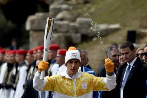 Greek cross-country skier Apostolos Angelis had the honor of being the first official torchbearer on this occasion. Here he also holds an olive tree branch as a symbol of peace.