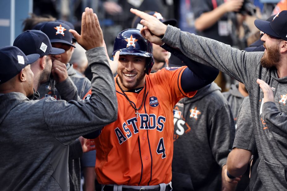 Springer is greeted in the dugout after scoring a run in the first inning. He opened the game with a double.