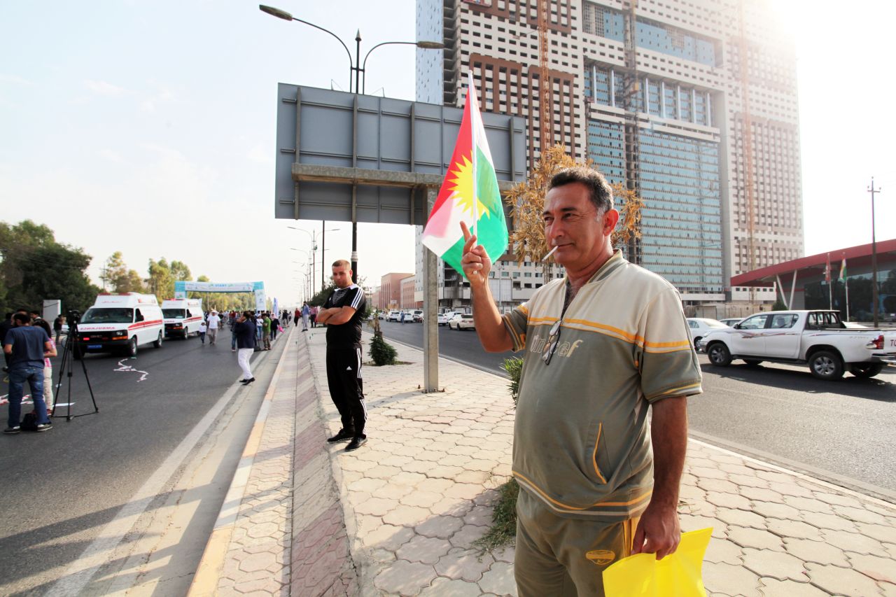 A supporter proudly waves the Kurdish flag during the race.