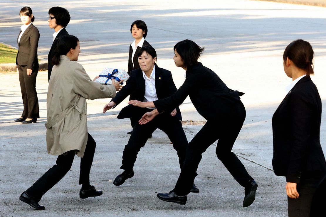 Female police officers wearing suits take part in a training on November 1 in Tokyo.