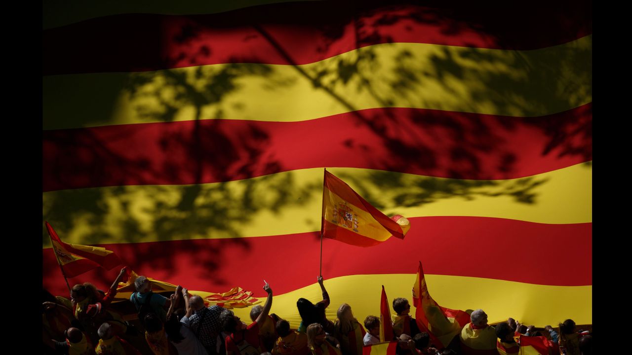 An activist waves a Spanish flag in front of a giant Catalan flag during a mass rally in Barcelona, Spain, on Sunday, October 29. <a href="http://www.cnn.com/2017/10/29/europe/catalonia-independence-spain/index.html" target="_blank">Hundreds of thousands of people gathered</a> to protest Catalonia's declaration of independence.