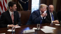 President Donald Trump kisses a printed example of what a new tax form may look like during a meeting on tax policy with Republican lawmakers in the Cabinet Room of the White House, Thursday, Nov. 2, 2017, in Washington, as House Speaker Paul Ryan of Wis., and chairman of the House Ways and Means Committee Rep. Kevin Brady, R-Texas, watch. (AP Photo/Evan Vucci)