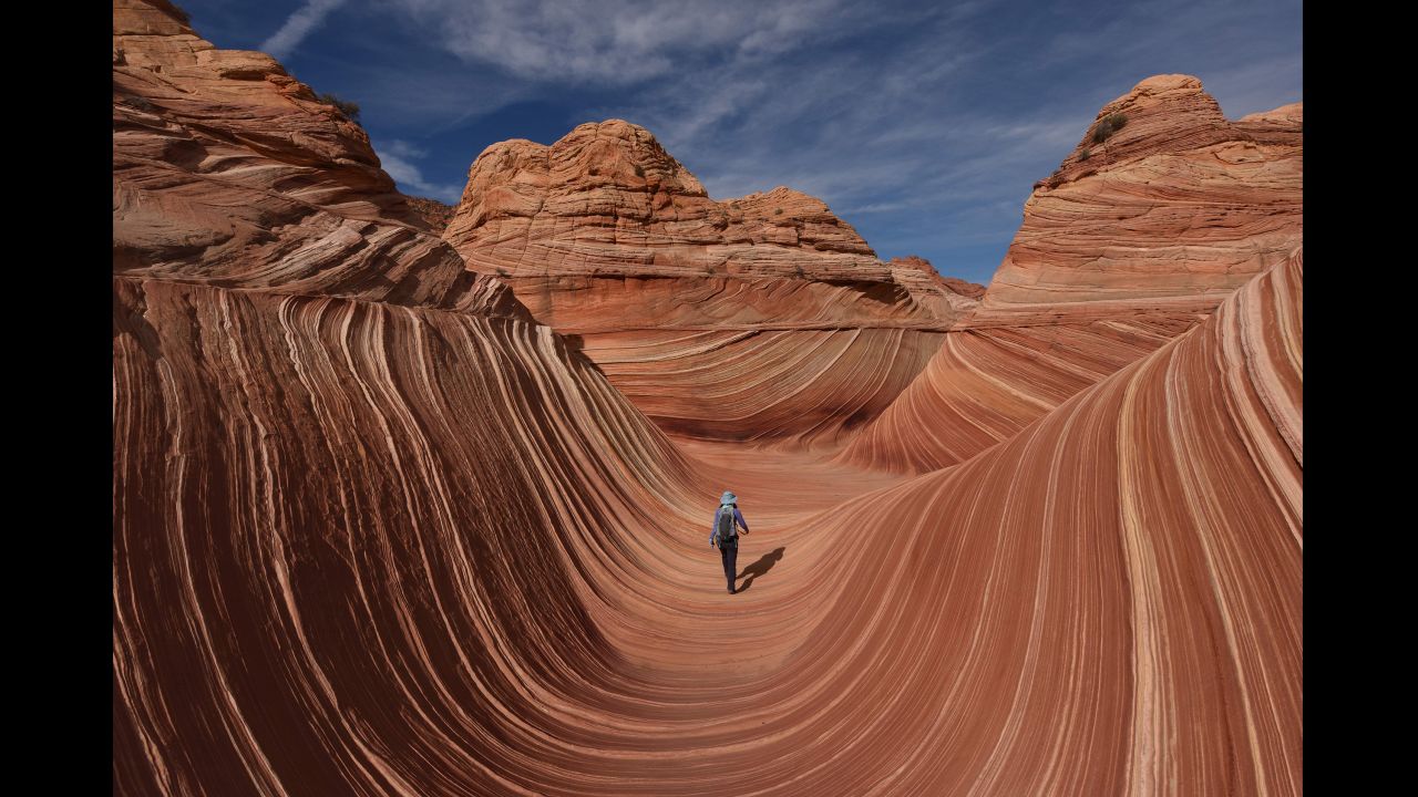 A hiker walks in the U-shaped troughs of The Wave near Page, Arizona, on Monday, October 30. The sandstone rock formation was created by a combination of water and wind erosion. Because of its fragile nature, access is limited to only 20 hikers per day.