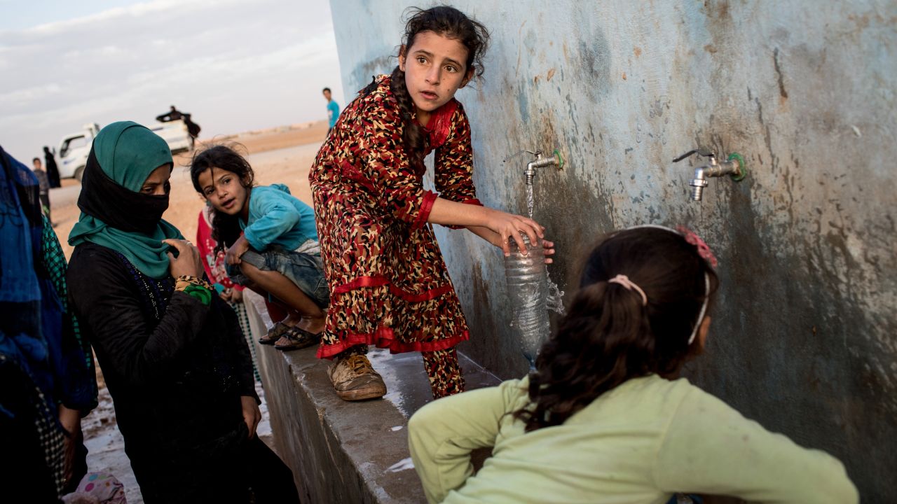A girl fills a bottle at a water pump station for internally displaced people in Ain Issa, Syria, on Sunday, October 29.