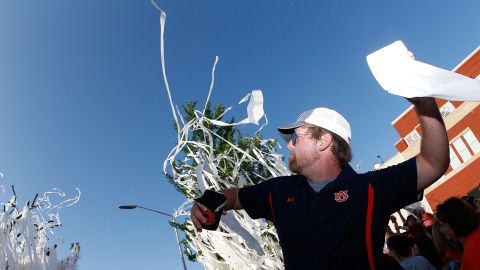 An Auburn fan throws a roll of toilet paper at Toomer's Corner. 