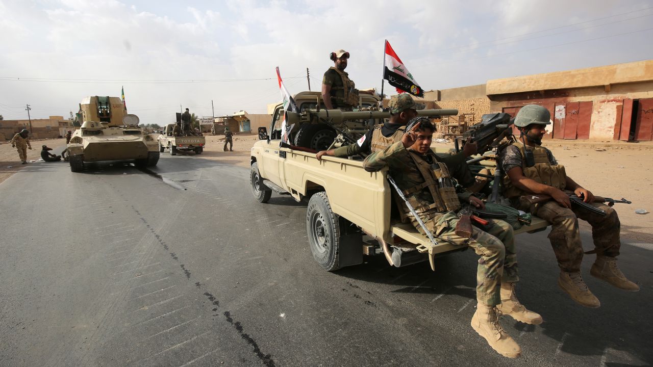 Iraqi forces and members of the Hashed al-Shaabi (popular mobilization units) enter Qaim on Friday.