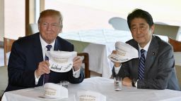 US President Donald Trump (L) and Japanese Prime Minister Shinzo Abe pose after they signed hats reading 'Donald and Shinzo, Make Alliance Even Greater' at the Kasumigaseki Country Club in Kawagoe, near Tokyo on November 5, 2017. 
Trump touched down in Japan, kicking off the first leg of a high-stakes Asia tour set to be dominated by soaring tensions with nuclear-armed North Korea. / AFP PHOTO / POOL / FRANCK ROBICHON        (Photo credit should read FRANCK ROBICHON/AFP/Getty Images)
