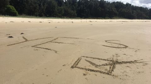 Melissa, Ebony and their family leave a message on the sands of Cape Conran, Victoria, on October 14.