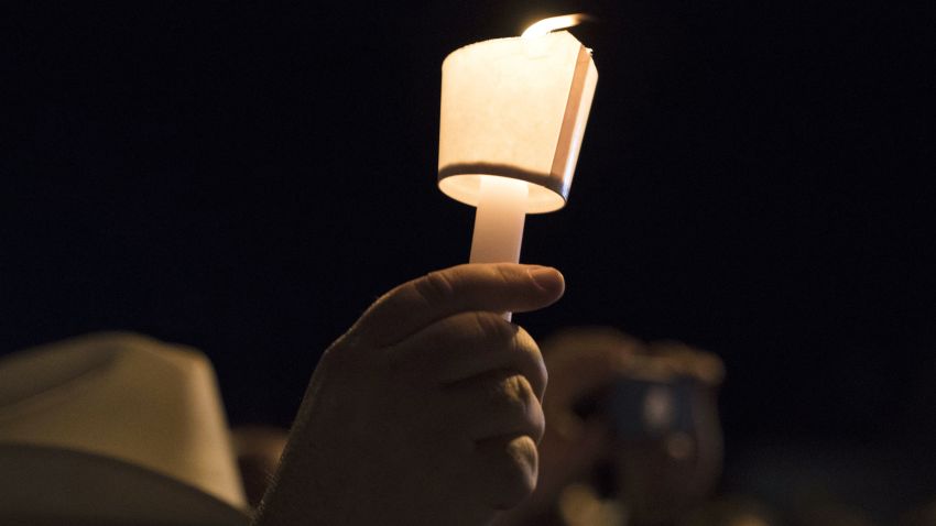 A mourner holds a candle during a vigil held for the victims of a fatal shooting at the First Baptist Church of Sutherland Springs, Sunday, Nov. 5, 2017, in Sutherland Springs, Texas. (AP Photo/Darren Abate)