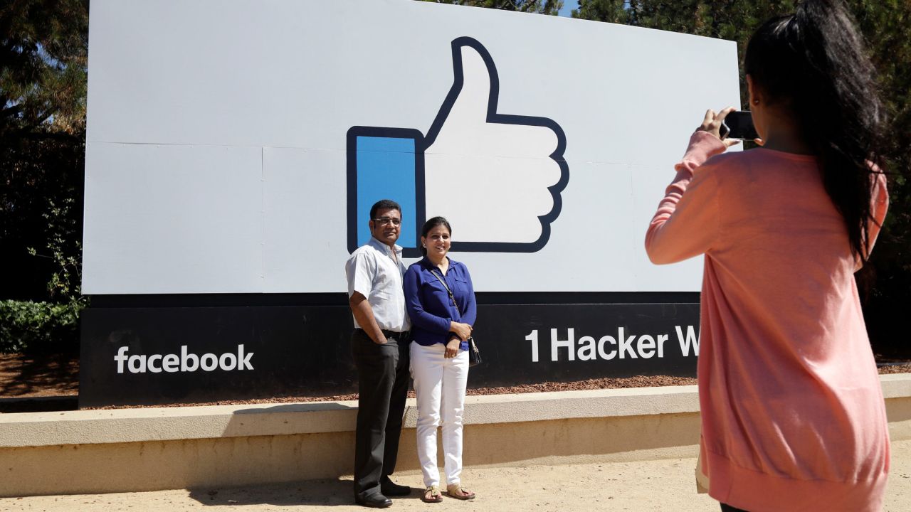 In this Aug. 31, 2016 photo, visitors take photos in front of the Facebook logo outside of the company's headquarters in Menlo Park , Calif. There's a quirky twist in tourism emerging amid the Silicon Valley whirlwind of innovation that has tethered everyone to their smartphones. Those omnipresent devices are now being used to track down technological touchstones so selfies can be taken, videos can be recorded and the experience can be celebrated in a Facebook post, Snapchat or tweet. (AP Photo/Marcio Jose Sanchez)
