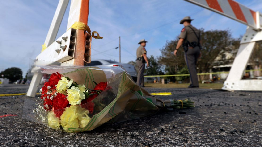 A bouquet of flowers lies near where law enforcement officials work outside First Baptist Church in Sutherland Springs.