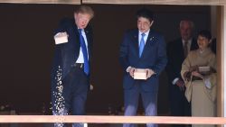 US President Donald Trump (C) feeds koi fish as Japanese Prime Minister Shinzo Abe (R)looks on during a welcoming ceremony in Tokyo on November 6, 2017.Trump lashed out at the US trade relationship with Japan, saying it was "not fair and open", as he prepared for formal talks with his Japanese counterpart. / AFP PHOTO / JIM WATSON        (Photo credit should read JIM WATSON/AFP/Getty Images)