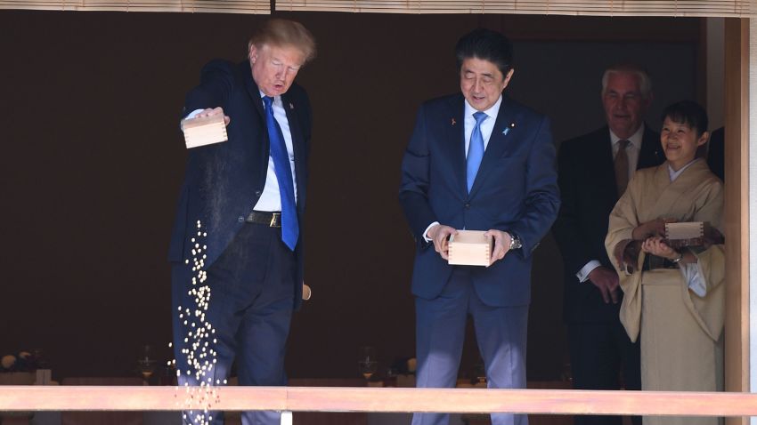 US President Donald Trump (C) feeds koi fish as Japanese Prime Minister Shinzo Abe (R)looks on during a welcoming ceremony in Tokyo on November 6, 2017.
Trump lashed out at the US trade relationship with Japan, saying it was "not fair and open", as he prepared for formal talks with his Japanese counterpart. / AFP PHOTO / JIM WATSON        (Photo credit should read JIM WATSON/AFP/Getty Images)