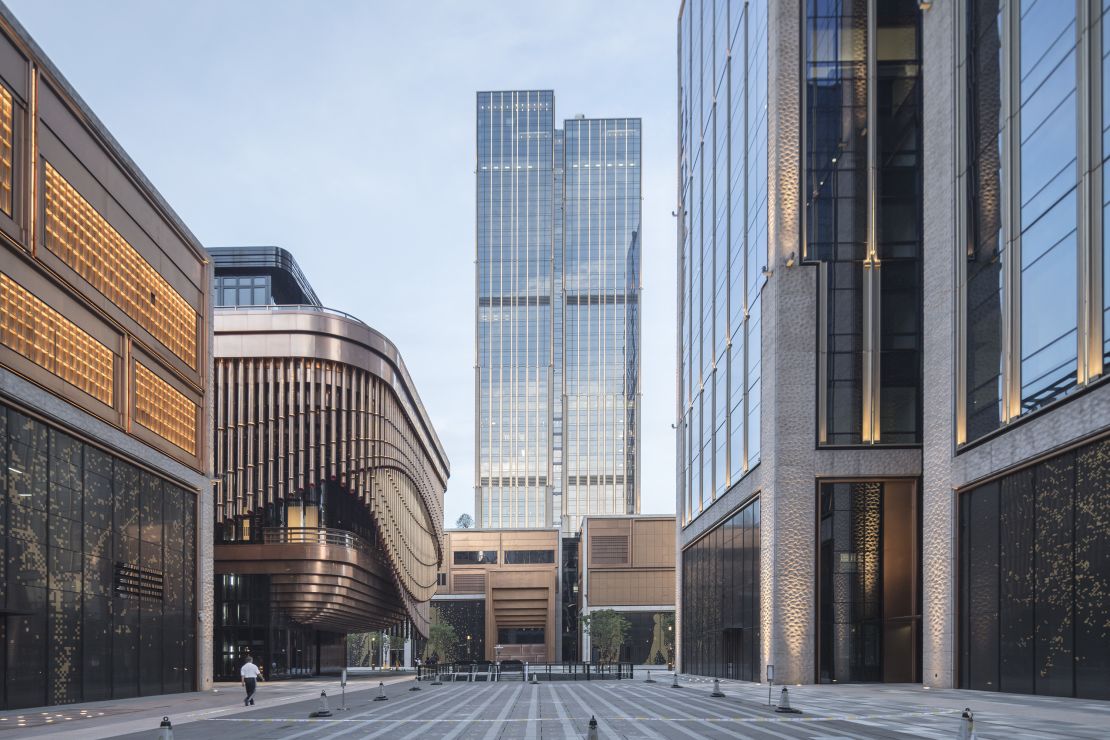 Two 180-meter tall towers (590 ft) sit south of the kinetic bronze arts and theater space. 