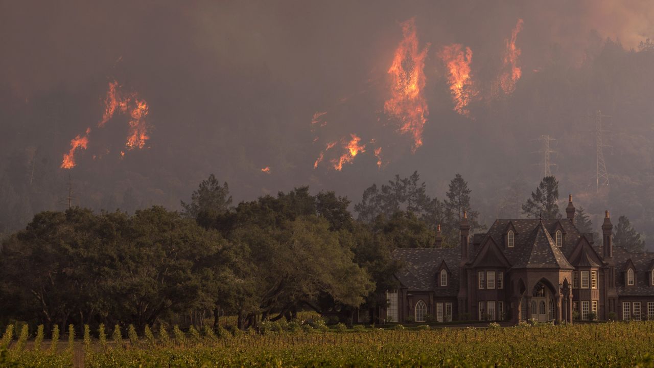 Flames rise behind Ledson Vineyards & Winery on October 14, 2017.