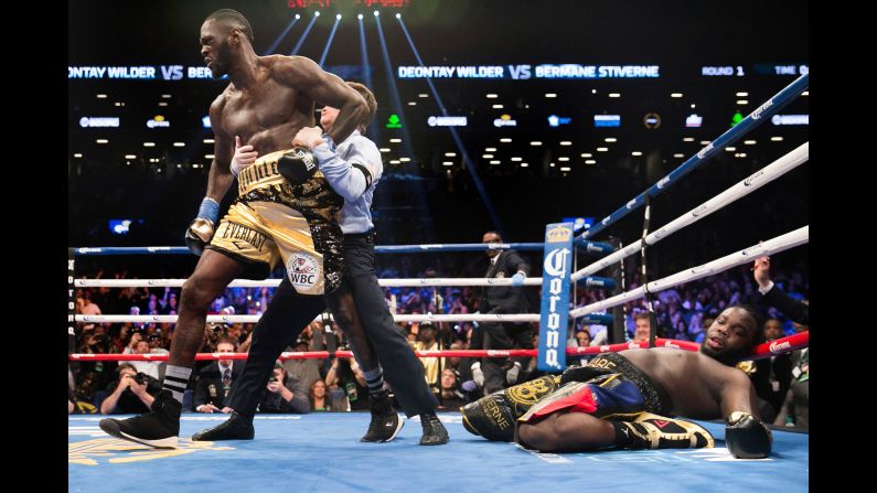 Referee Arthur Mercante pulls Deontay Wilder away from Bermane Stiverne after Wilder's first-round victory in New York on Saturday, November 4. Mercante stopped the fight after Wilder, the WBC heavyweight champion, floored Stiverne for the third time in the round.