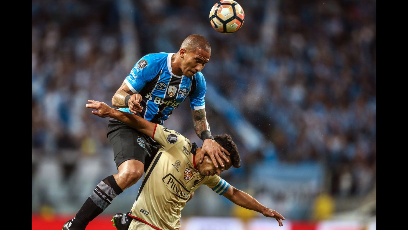 Gremio midfielder Jailson jumps over Barcelona's Matias Oyola during a Libertadores Cup match in Porto Alegre, Brazil, on Wednesday, November 1. 