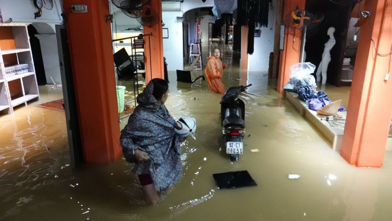 Residents stand inside their flooded home in Hoi An on Monday.