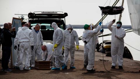 Workers prepare a coffin at the harbor.