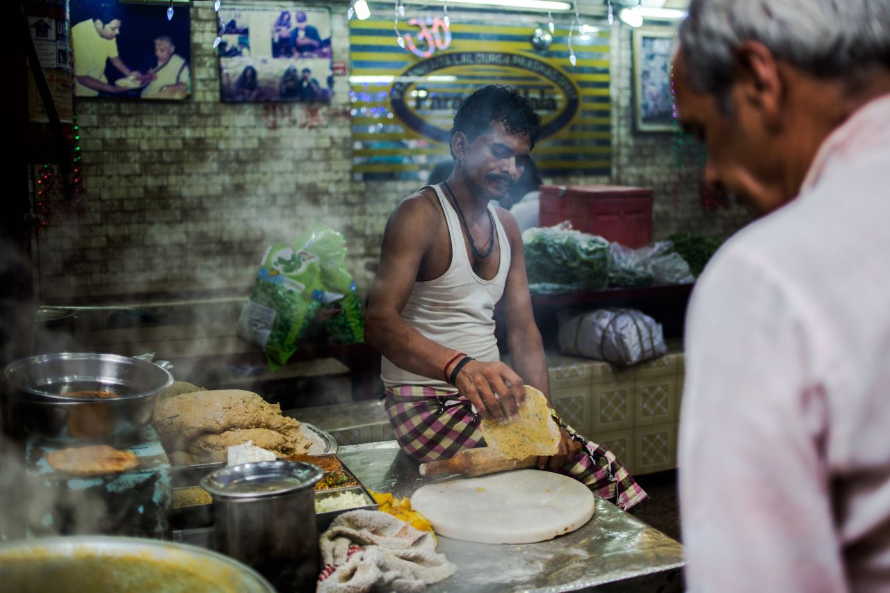 An Indian cook makes parathas, fried stuffed bread, at a shop in Paranthe Wali Gali.