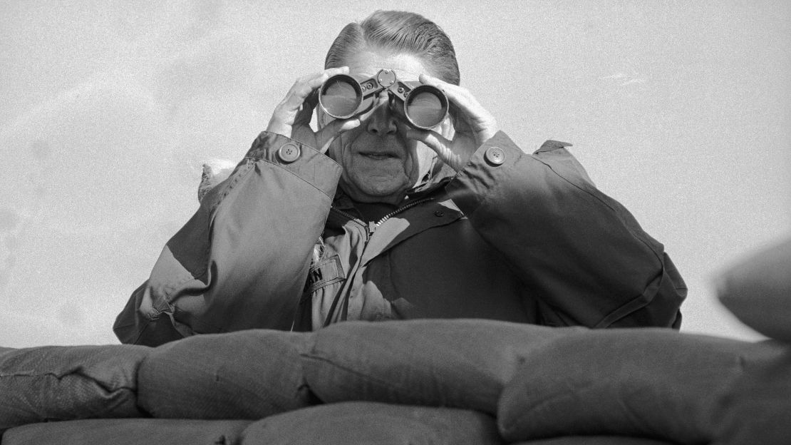 Reagan looks through binoculars to view North Korean positions from the observation deck at Guard Post Collier at the DMZ in 1983.