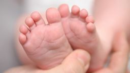 Mothers hands holding little newborn baby feet.