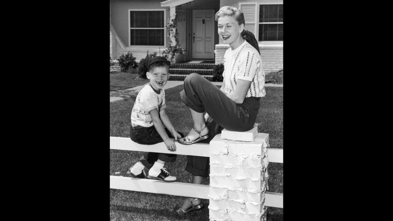 Day sits on a fence with her son, Terry, in front of their home. Terry was her only child.