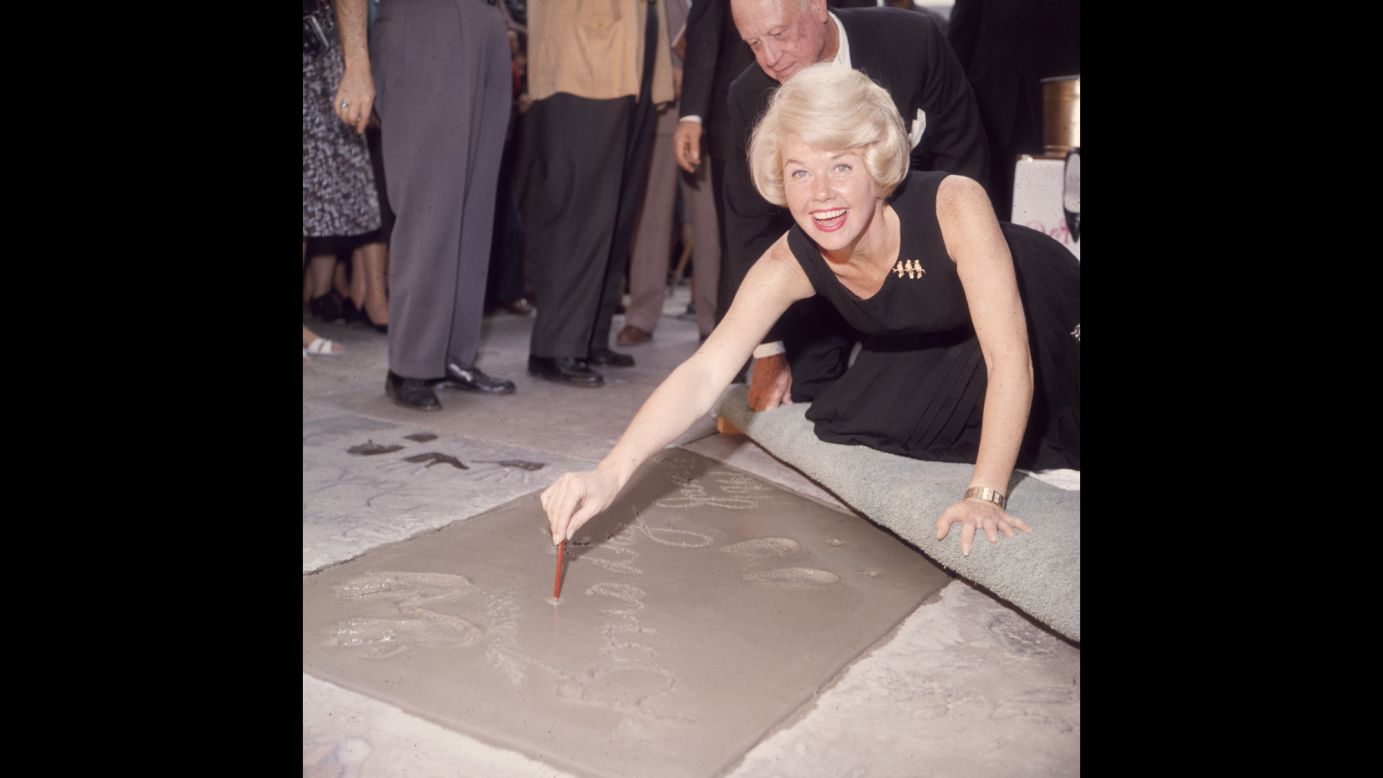 Day signs her name in wet cement next to her handprints in Hollywood. In 1960, Day received two stars on the Hollywood Walk of Fame: one for music and one for film.