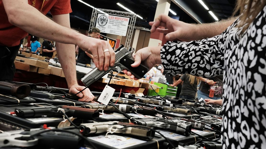 A woman tries a pistol at a gun show in July 2016 in Fort Worth, Texas.