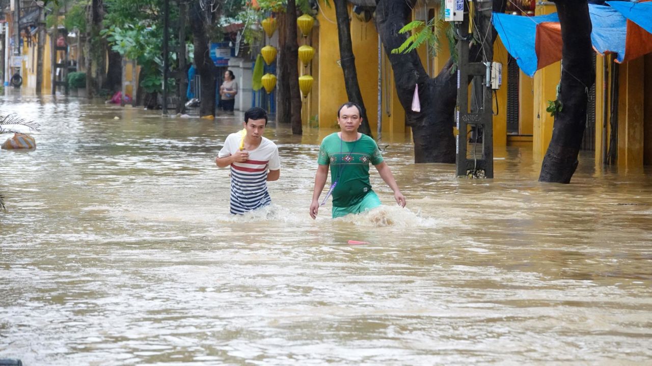 Local residents wade through flood waters at the central tourist town of Hoi An on November 6, 2017.