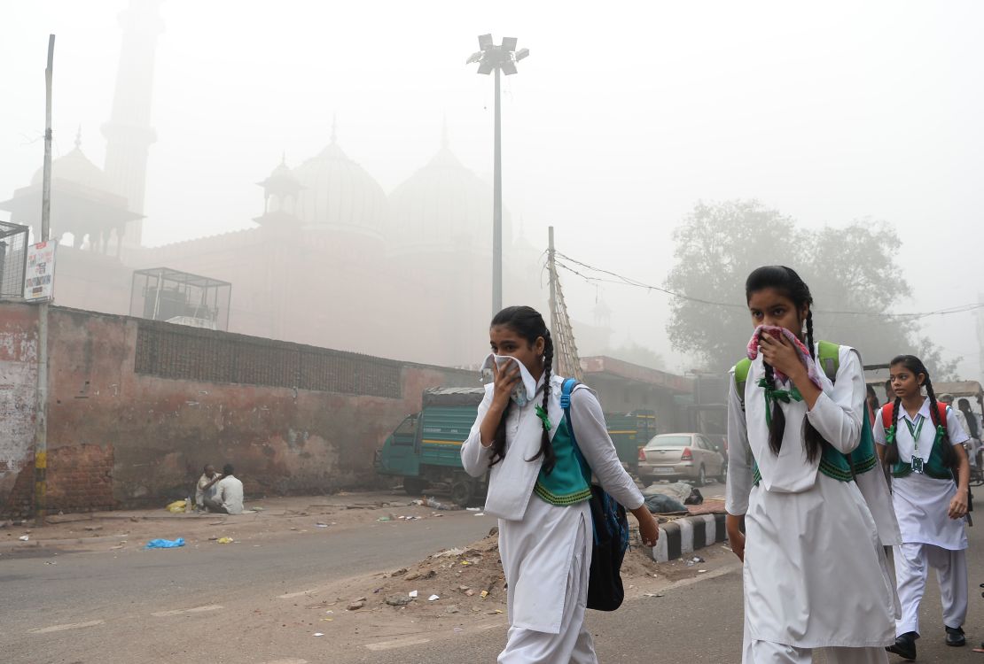 Indian schoolchildren cover their faces as they walk to school, November 8, 2017. Delhi has since mandated the closure of all schools until the pollution clears. 