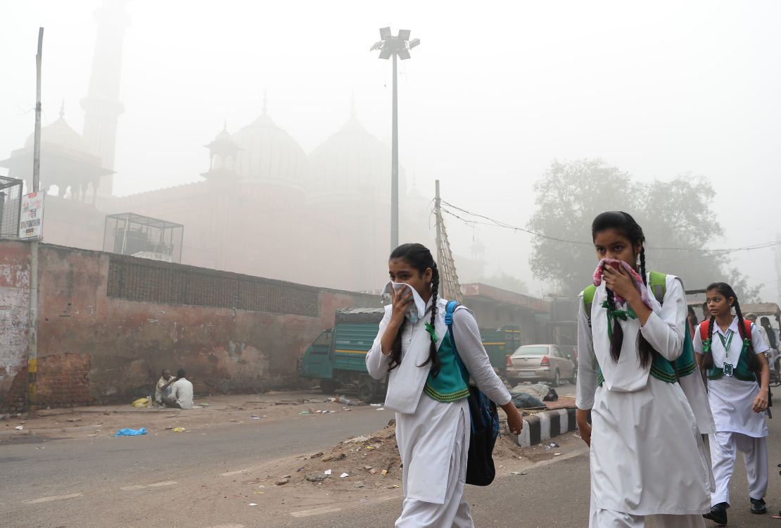 Indian schoolchildren cover their faces as they walk to school, November 8, 2017. Delhi has since mandated the closure of all schools until the pollution clears.