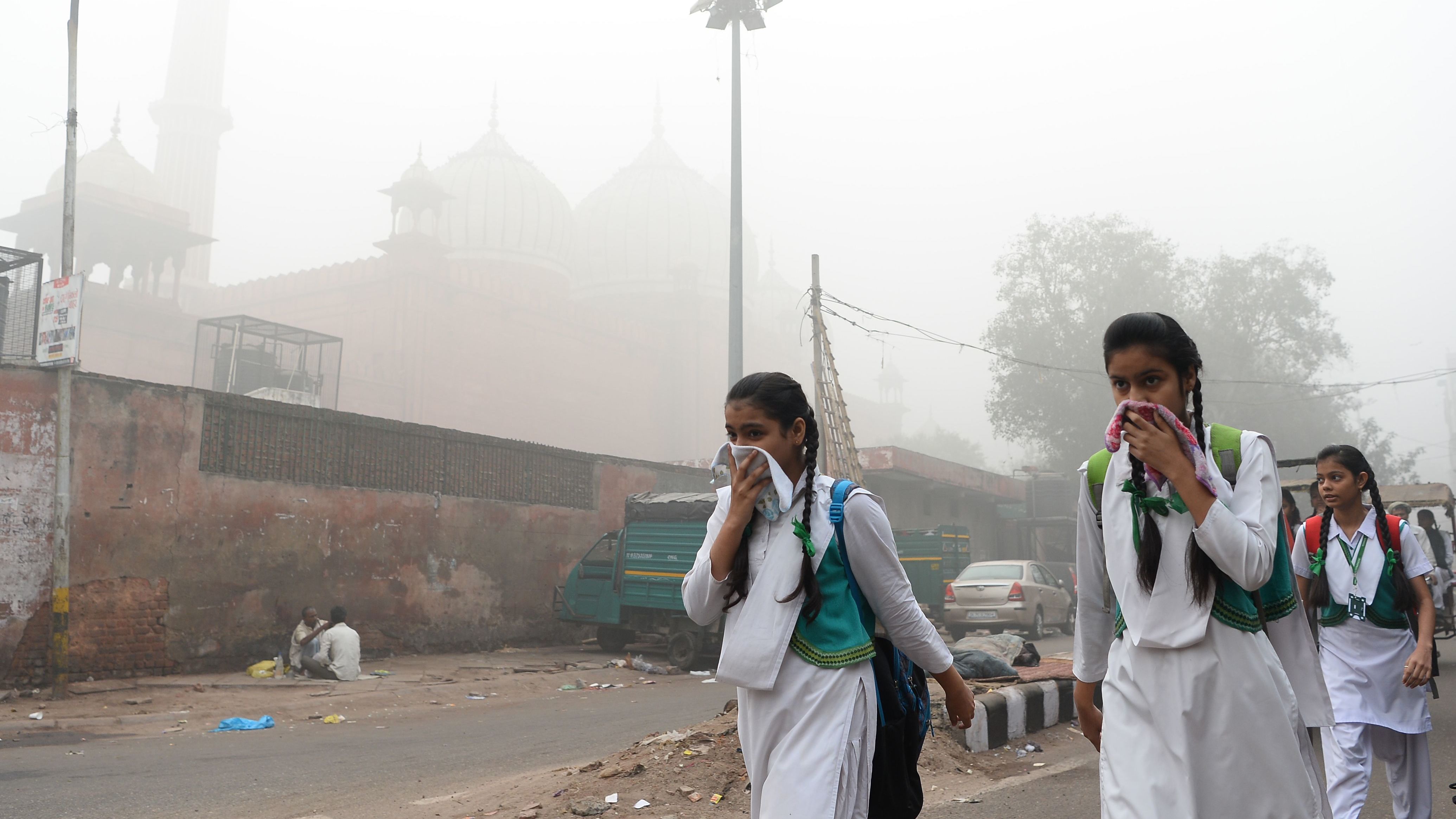 Indian schoolchildren cover their faces as they walk to school, November 8, 2017. Delhi has since mandated the closure of all schools until the pollution clears. 