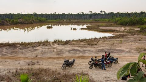 A group of motorcycle taxis known as "Los Tigres" stops near a toxic mining site in the Peruvian Amazon.