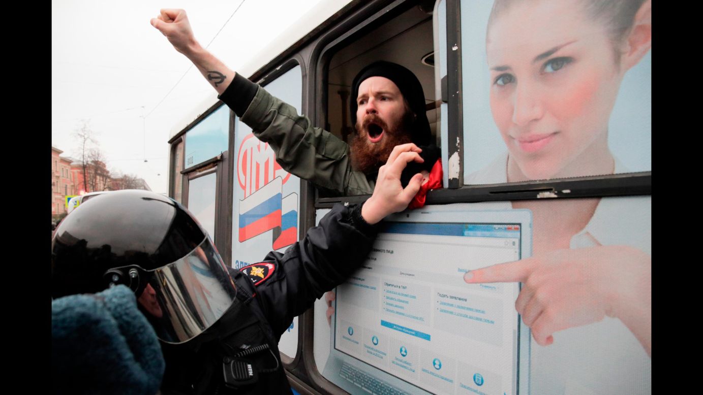 A detained member of the Other Russia movement shouts from a police bus in St. Petersburg, Russia, during an unauthorized rally to mark the centenary of the Bolshevik Revolution on Monday, November 6.