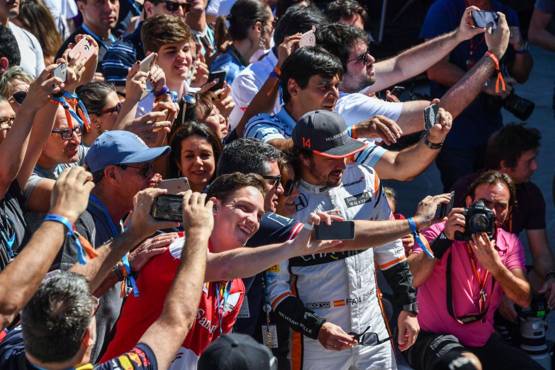 Alonso poses with fans for selfies before the Brazilian Formula One Grand Prix in 2017.