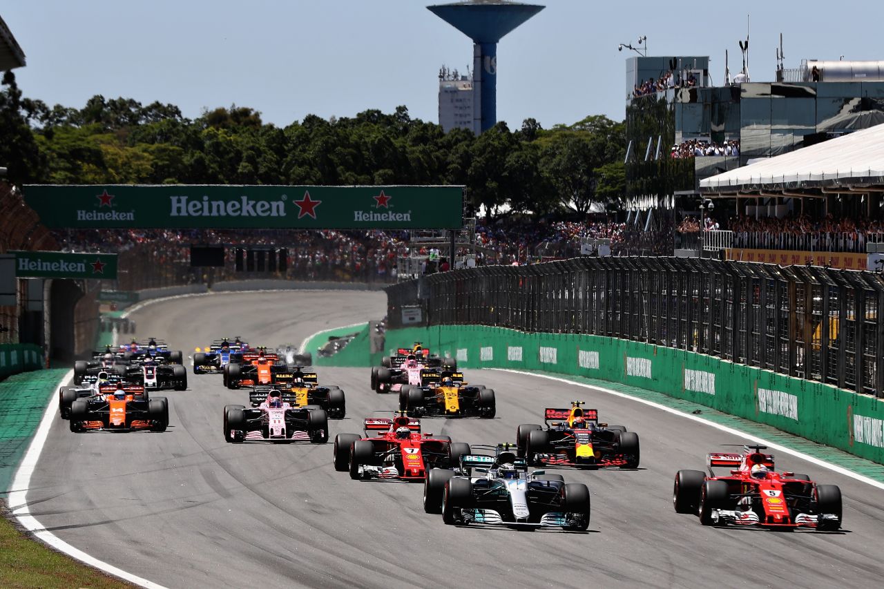 Vettel (right) draws level with pole sitter Valtteri Bottas at the start of Sunday's Brazilian Grand Prix.