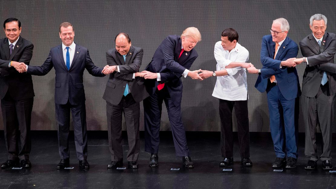 (L-R) Thailand's Prime Minister Prayut Chan-O-Cha, Russian Prime Minister Dmitry Medvedev, Vietnam's Prime Minister Nguyen Xuan Phuc, US President Donald Trump, Philippine President Rodrigo Duterte, Australia Prime Minister Malcolm Turnbull and Singapore's Prime Minister Lee Hsien Loong join hands for the family photo during the 31st Association of South East Asian Nations (ASEAN) Summit in Manila on November 13, 2017. 
