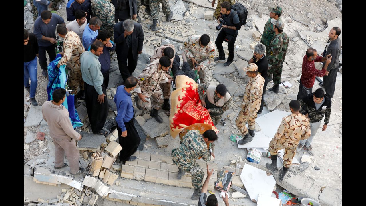 Rescue workers carry a victim's body out of a collapsed building in Sarpol-e-Zahab on November 13.
