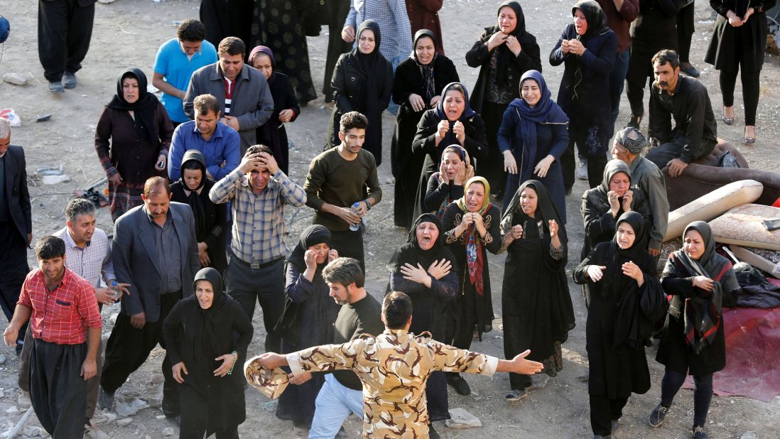 People try to get closer to the body of a relative who was killed in Sarpol-e Zahab.